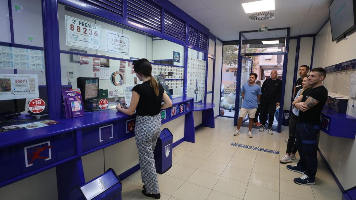 Algunas personas haciendo cola esta tarde en la Administración de Elche.