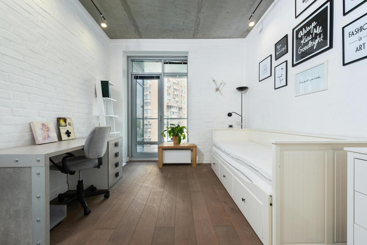 Estudio con despacho y cama enfrente.